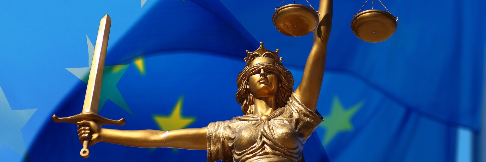 Römische Göttin Justitia vor einer europäischen Flagge